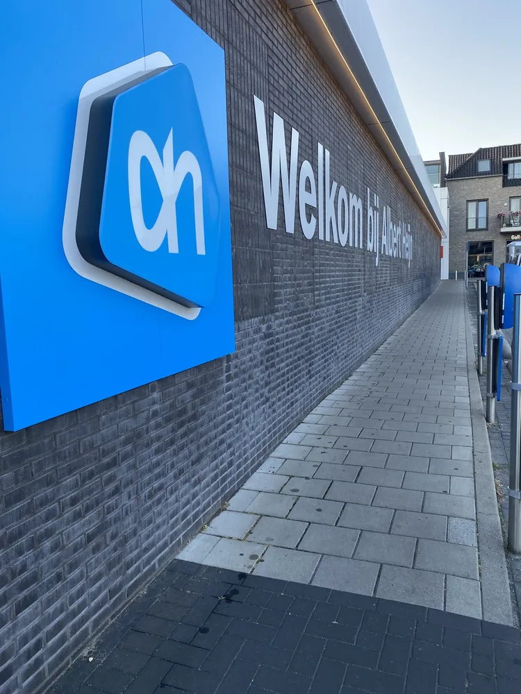 Gereinigde bestrating met Albert Heijn logo bij de entree
